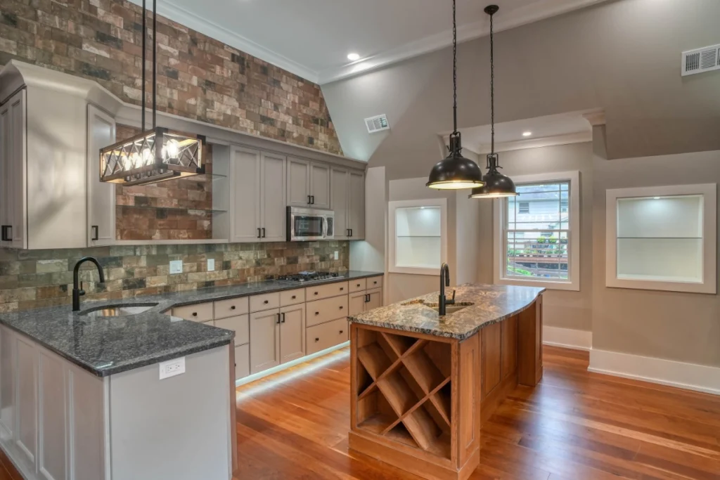 Modern kitchen with white cabinetry, granite counters, and wooden island.