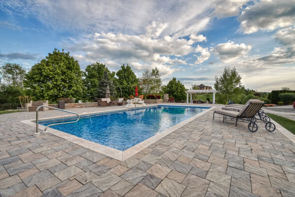Luxurious backyard swimming pool with lounge chairs and manicured landscape.